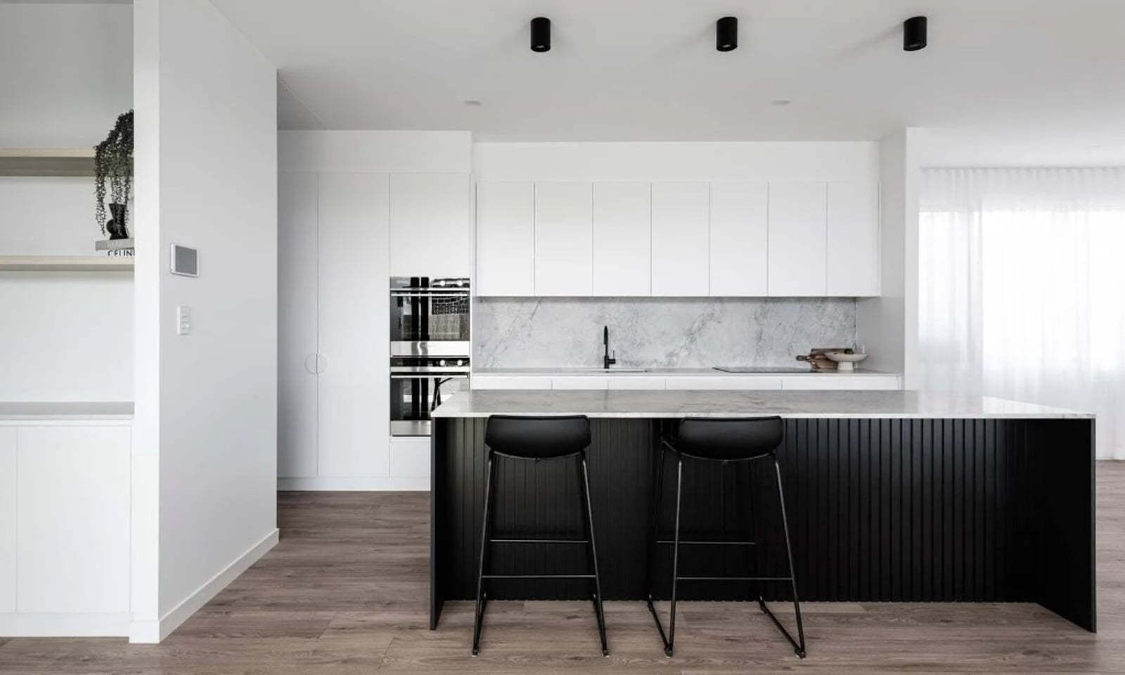 Project Moncrief (Black slatted island with marble benchtop, white cabinetry and integrated ovens)