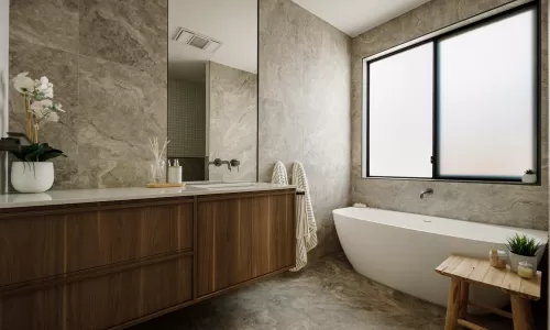 Modern bathroom with freestanding tub, wood vanity, stone tile, and frosted glass window.