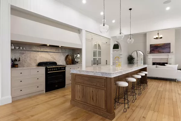  Kitchen with island, black stove, and pendant lights.