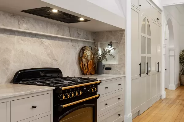 Kitchen with marble backsplash and a black stove.