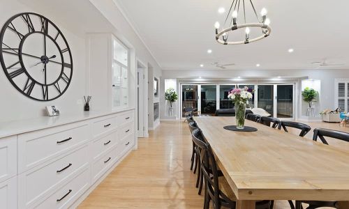 dining area with clock and white colored cabinets