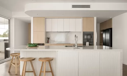 Modern kitchen with marble island and wood stools