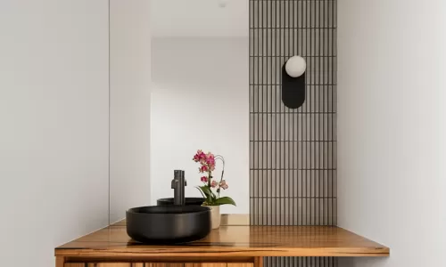 modern bathroom with a wooden vanity and black countertop sink with a wall-mounted mirror