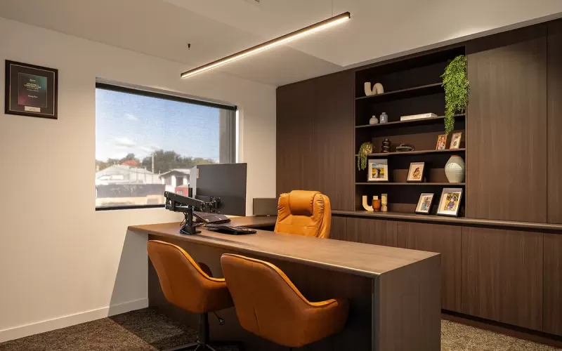 Executive office with brown chairs and wall shelving