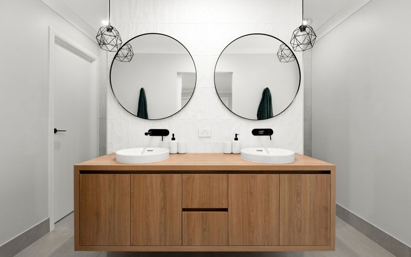 circular mirror over bathroom sink