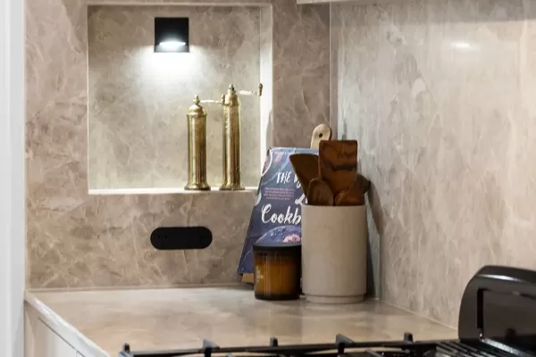 Kitchen with marble backsplash, black stove.