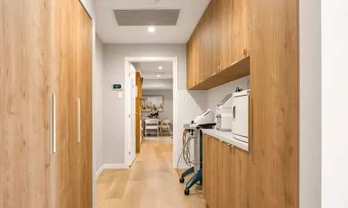 Clinic corridor with wood cabinets and equipment.