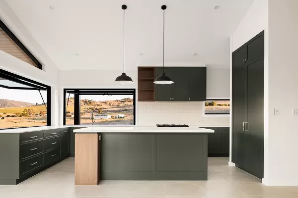 Bright kitchen with green cabinetry and open windows