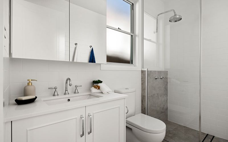 white themed bathroom cabinets and shower area