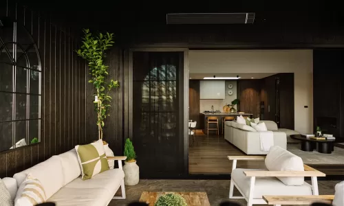 Open-concept space with cozy patio seating and view into modern kitchen and living room.