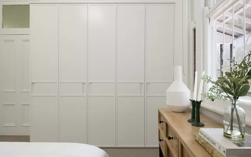 White built-in wardrobe with panelled doors.