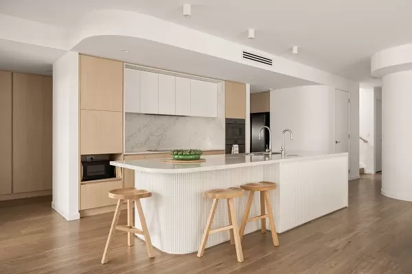 Minimalist kitchen with island and three wooden stools