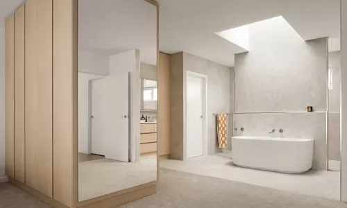 Modern ensuite with tub under skylight and wood panels