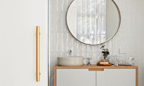 Drummond street bathroom's powder area with single sink and round mirror