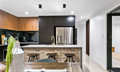 kitchen sink with gold faucet and wooden cabinets
