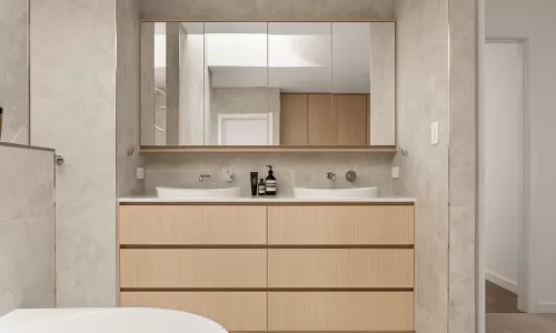 Double sink vanity with mirror in tiled bathroom