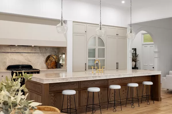 Kitchen with island, black stove, and bar stools.