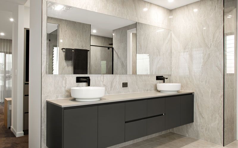 wide mirror with black bathroom cabinets