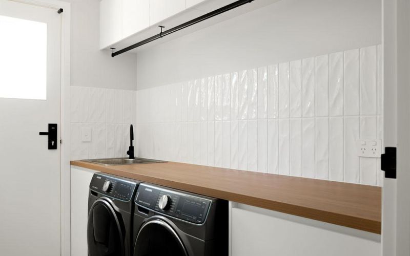 White laundry room with black washing machine