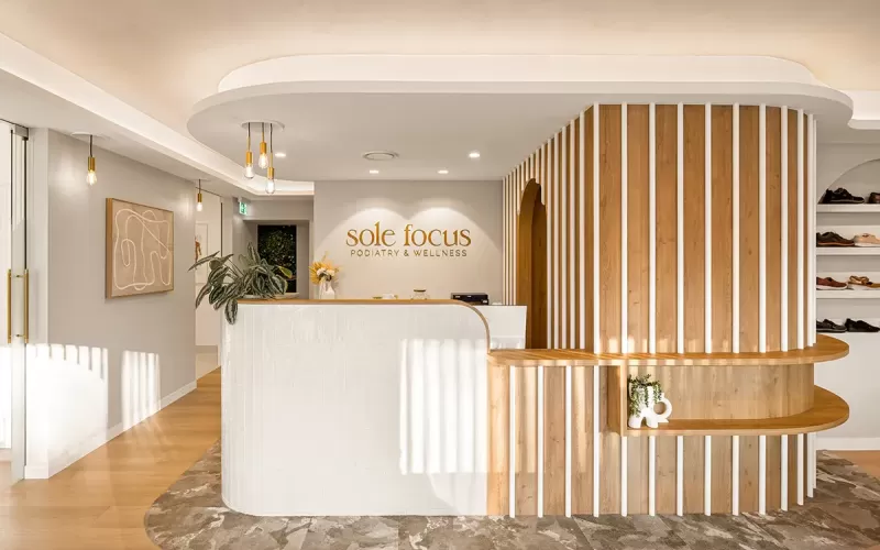 Curved reception desk at Sole Focus with warm lighting.