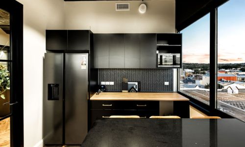 black refrigerator and kitchen cabinets