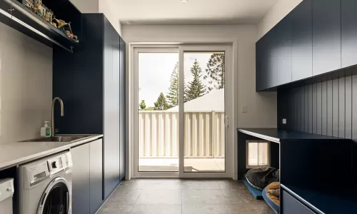 Laundry with navy cabinetry, washer, and pet nook