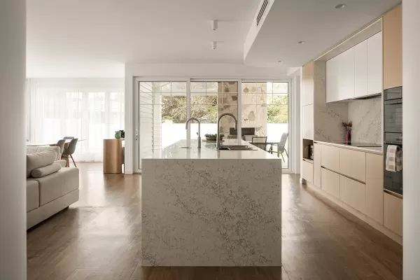 Bright kitchen island with dual sinks and patio view