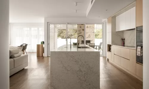Stone kitchen island facing patio with glass doors