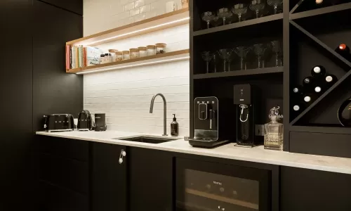 Modern kitchen with black cabinetry, white subway tile backsplash, and Smeg appliances on the countertop