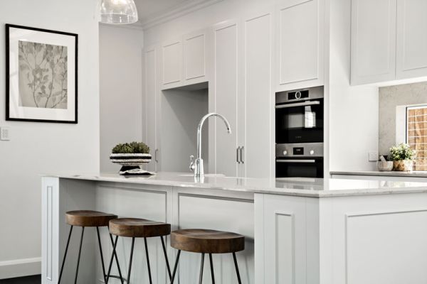 Silver sink in white themed kitchen
