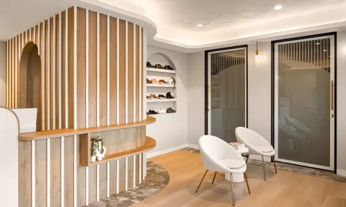 Modern podiatry waiting area with chairs and shelving.