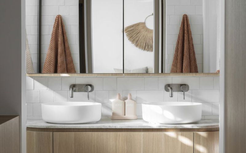 Palmera bathroom sink with towels in the reflection of a mirror