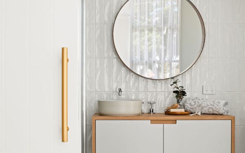 Drummond street bathroom's powder area with single sink and round mirror