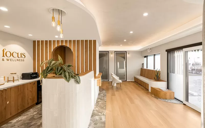 Reception area with desk, seating, and full glass doors.