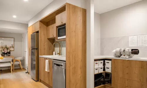 Clinic kitchenette and workspace with wood cabinets.