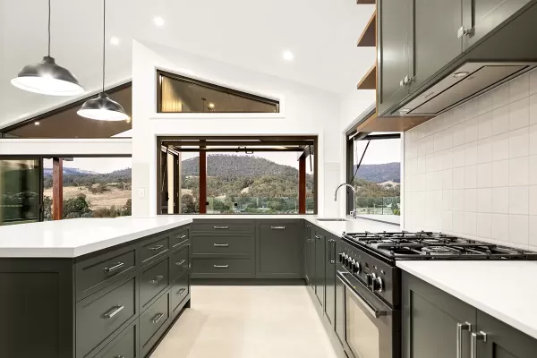 Sleek kitchen with mountain view and dark cabinets