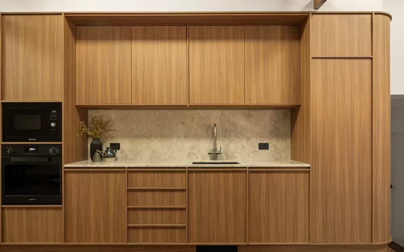 Built-in kitchenette with wood panels and marble top