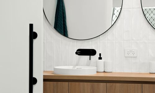bathroom white sink with black faucet and half view of mirror