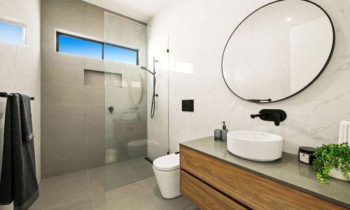 bathroom with circular mirror and glass divider